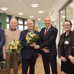 Menschen mit Blumen lächeln in die Kamera