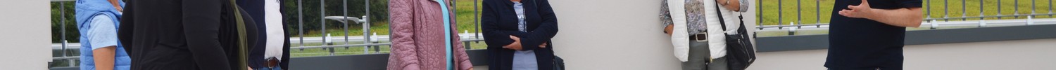 Ein Mitarbeiter informiert eine Gruppe Besucher:innen auf der Dachterasse des LWL-Therapiezentrums für Forensische Psychiatrie Münsterland.